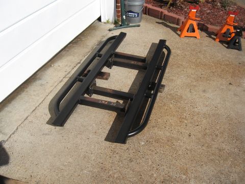 1994 Ford Bronco - Rock sliders, possibly for a 4x4, are laid out on a concrete surface.