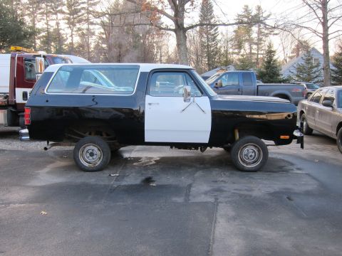 1987 Dodge 1500 - This two-tone SUV has a black rear section and a white front door, suggesting it is undergoing repairs or customization.