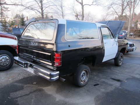 1987 Dodge 1500 - This 1987 Dodge Ramcharger is shown from the rear quarter with a two-tone black and white paint scheme and its hood is open.