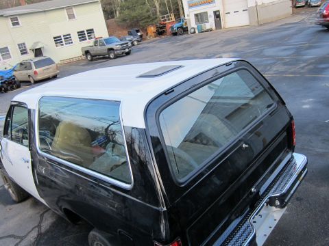 1987 Dodge 1500 - SUV with a two-tone black and white paint scheme, seen from the rear quarter angle.
