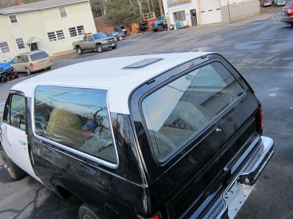 Black and white two-tone SUV, rear quarter view. Sunroof on white roof
