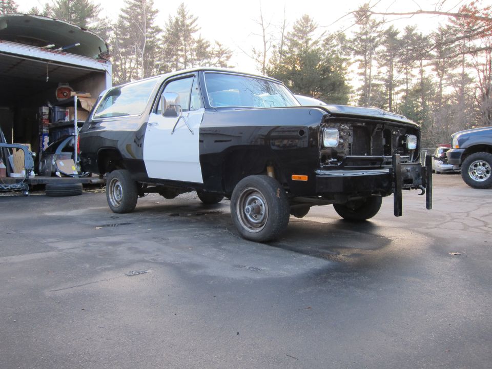 Black and white Dodge Ramcharger with front end missing parts, parked outside