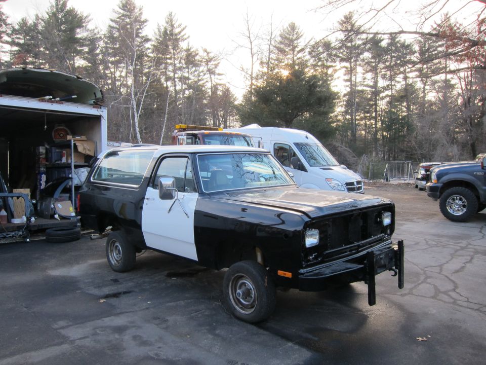 Black and white Dodge Ramcharger with missing grille and front bumper, parked outdoors