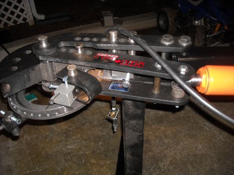 1979 Ford F-150 - A close-up view of a metal tube bender, showing its intricate mechanical components and hydraulic cylinder.