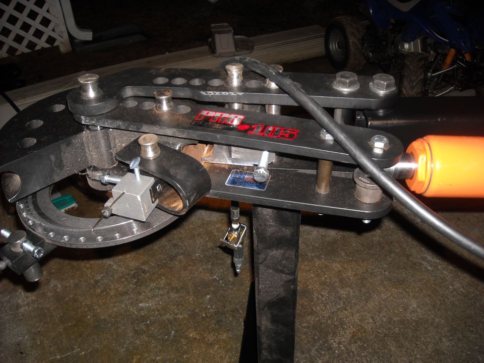 Black tube bender with orange hydraulic cylinder and degree guide