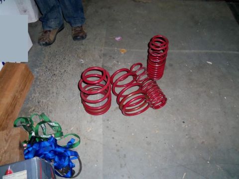 2000 Mercury Grand Marquis - A collection of red coil springs, likely for a vehicle, are displayed on the ground with tie-down straps nearby.