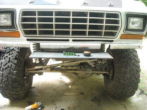 1979 Ford F-150 - Close-up of the front grille and massive tires on a 1979 Ford F-150, with a custom metal plate installed below the bumper.