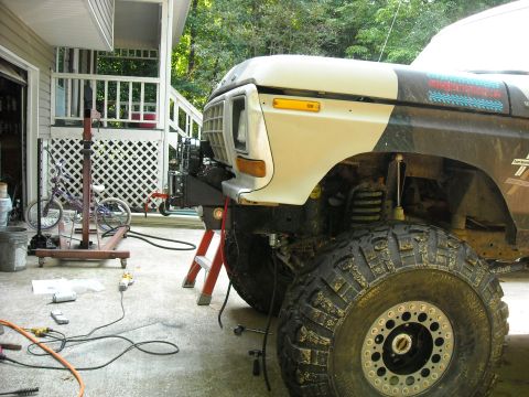 1979 Ford F-150 - Front view of a lifted 1979 Ford F-150 with large off-road tires, undergoing modifications in a garage.