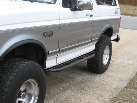 1994 Ford Bronco - Side profile of a 1994 Ford Bronco with aftermarket running boards and off-road tires.