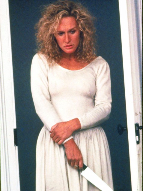 1994 Jeep Cherokee - A woman stands with her arms crossed, holding a knife, looking down with a troubled expression.