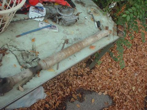 1993 Ford Bronco - A driveshaft and carburetor are visible on a table outdoors.