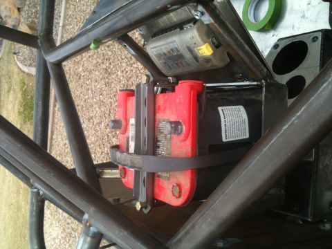 1966 Ford Bronco - A close-up view of a vehicle's battery and fuse box assembly, mounted inside a custom roll cage structure.