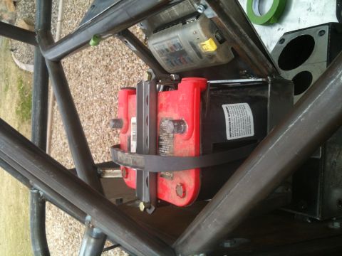 1966 Ford Bronco - A close-up view shows a red Optima battery and a fuse box mounted inside a custom roll cage structure.