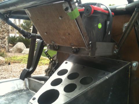 1966 Ford Bronco - Custom interior of an off-road vehicle shows a battery, pedals, and fabricated metal components.