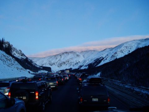 2009 Kenworth T800 - A long line of vehicles is stuck in traffic on a mountain pass during winter.