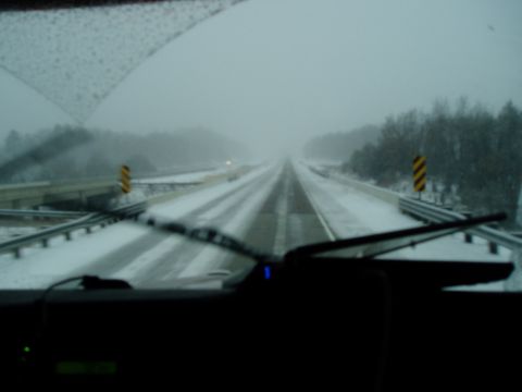 2009 Kenworth T800 - Driving through a snowstorm on a highway, visibility is low.