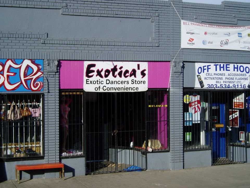 Storefront with 'Exotica's Exotic Dancers Store of Convenience' sign and 'Off The Hook' cell phone store