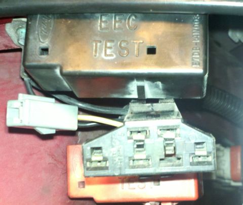 1995 Ford Bronco - Close-up of a vehicle's engine bay showing an electronic control module labeled 'EEC TEST'.