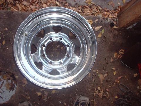 1993 Ford Bronco - A single chrome wheel is shown, lying on the ground amidst fallen leaves and dirt.