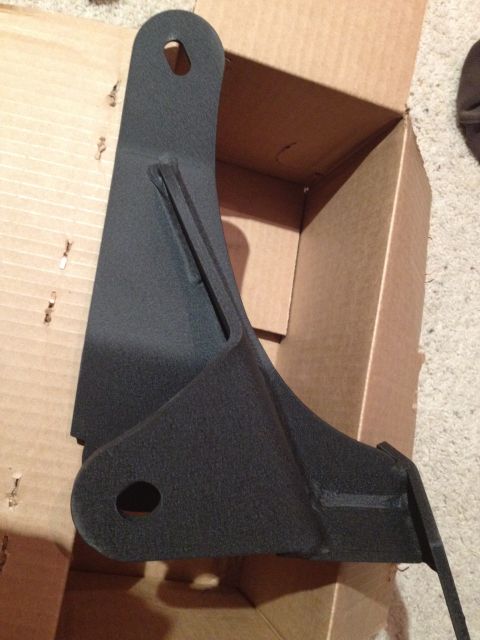 1995 Ford Bronco - A black metal bracket, likely a vehicle part, is shown inside a cardboard box.