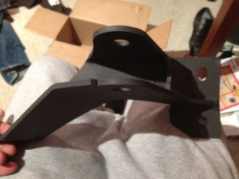 1995 Ford Bronco - A black metal bracket, possibly a vehicle part, is held in a person's hand.