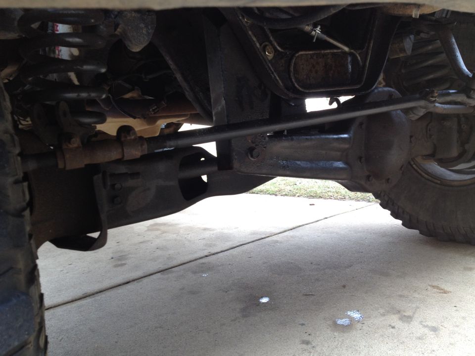 Underside view of a truck front axle, steering linkage and differential