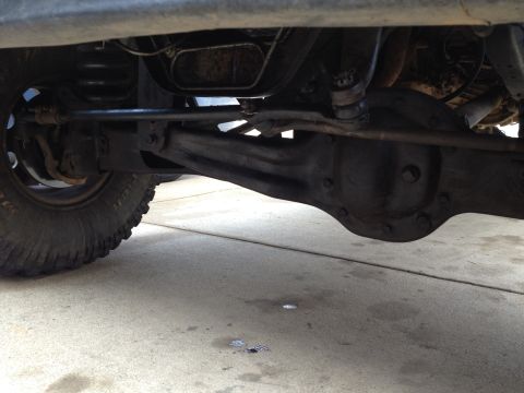 1995 Ford Bronco - Close-up of the front axle and suspension system of a vehicle, showing mechanical parts.