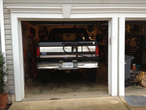 1995 Ford Bronco - Rear view of a black 1995 Ford Bronco parked in a garage, equipped with a bike rack and a license plate reading XLY-5487.