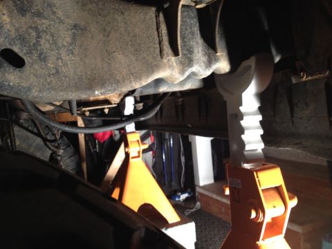 1995 Ford Bronco - The vehicle's undercarriage is visible, supported by jack stands for maintenance.
