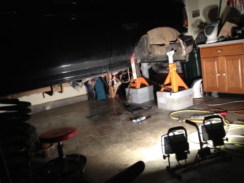 1995 Ford Bronco - Vehicle is on jack stands in a garage, undergoing maintenance or repair.