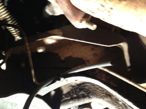1995 Ford Bronco - Close-up view of a vehicle's undercarriage, showing various mechanical parts and wiring.