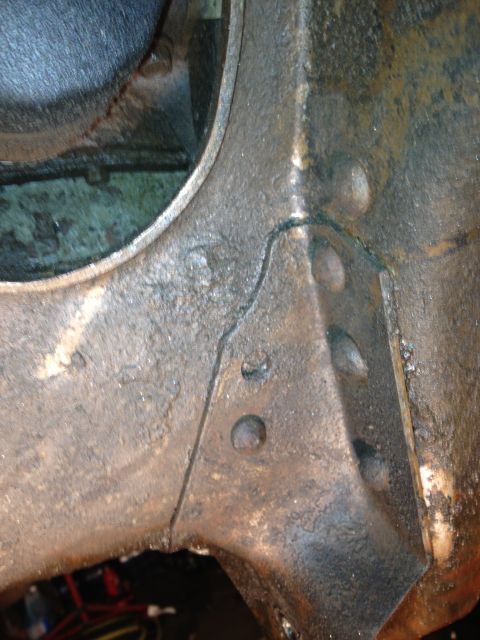 1995 Ford Bronco - This image shows a close-up of a vehicle's frame, revealing damage and grease buildup.