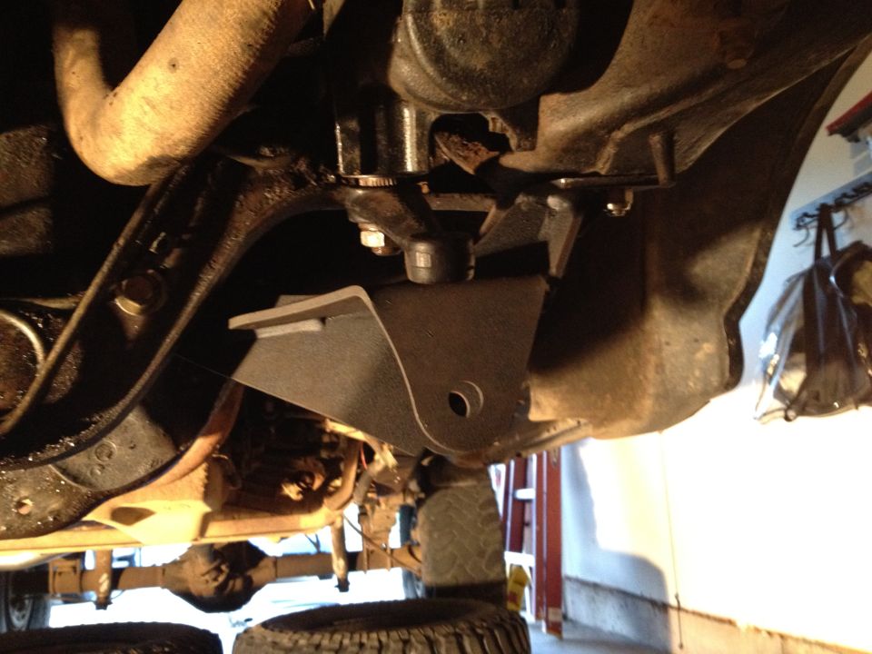 Close-up of a metal bracket attached to the underside of a vehicle's frame