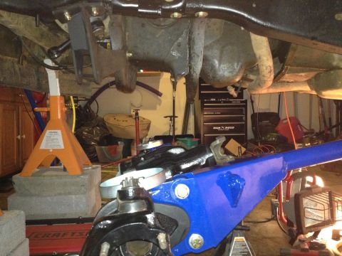 1995 Ford Bronco - Vehicle undercarriage work in progress, with suspension parts and tools visible.