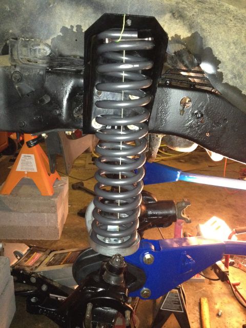 1995 Ford Bronco - Close-up view of a vehicle's front suspension system, focusing on the coil spring and associated hardware.