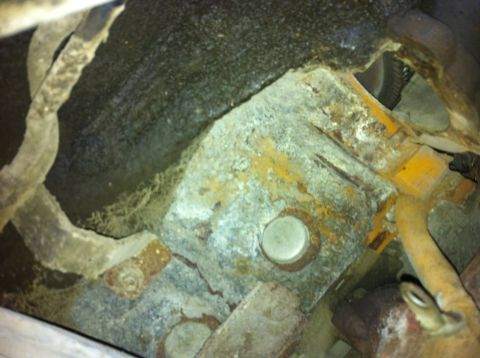 1998 Ford Crown Victoria - Close-up view of heavily corroded mechanical parts and wiring, with a partial yellow component.