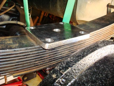 1995 Ford Bronco - Metal plate attached to a leaf spring, likely part of a suspension modification.