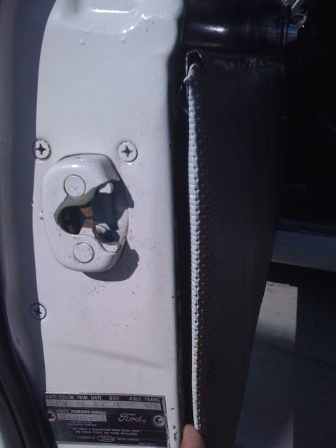 1964 Ford Ranchero - Close-up of the door latch mechanism and interior trim panel, showing the VIN plate on a 1964 Ford Ranchero.