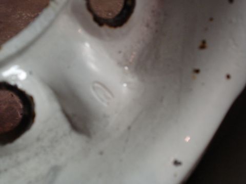 1967 Ford F-250 - This is a close-up of a white painted metal part with visible bolt holes and a faint marking.