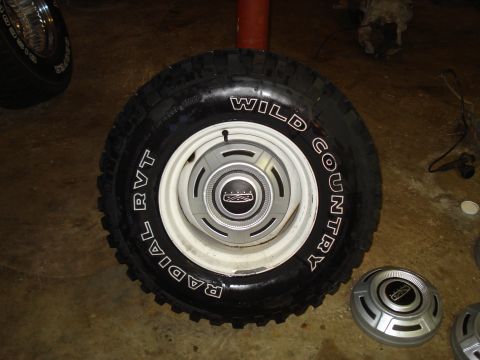 1967 Ford F-250 - A tire and wheel assembly is shown, with additional hubcaps visible in the background.