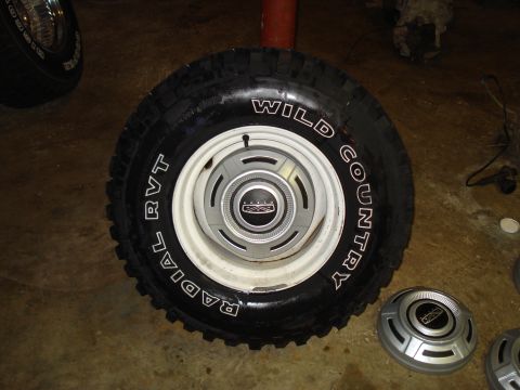 1967 Ford F-250 - A close-up of a tire and wheel assembly, 'Wild Country Radial RVT' text on the tire and a chrome hubcap with a central emblem.