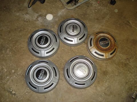 1967 Ford F-250 - Set of five hubcaps, four in good condition and one showing rust.