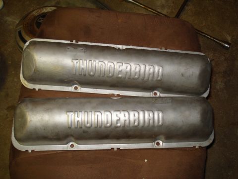 1967 Ford F-250 - Two aluminum valve covers, each embossed with "THUNDERBIRD", are shown resting on a brown surface.