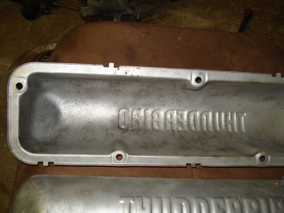 Two aluminum engine valve covers, one with embossed text 'THUNDERBIRD'
