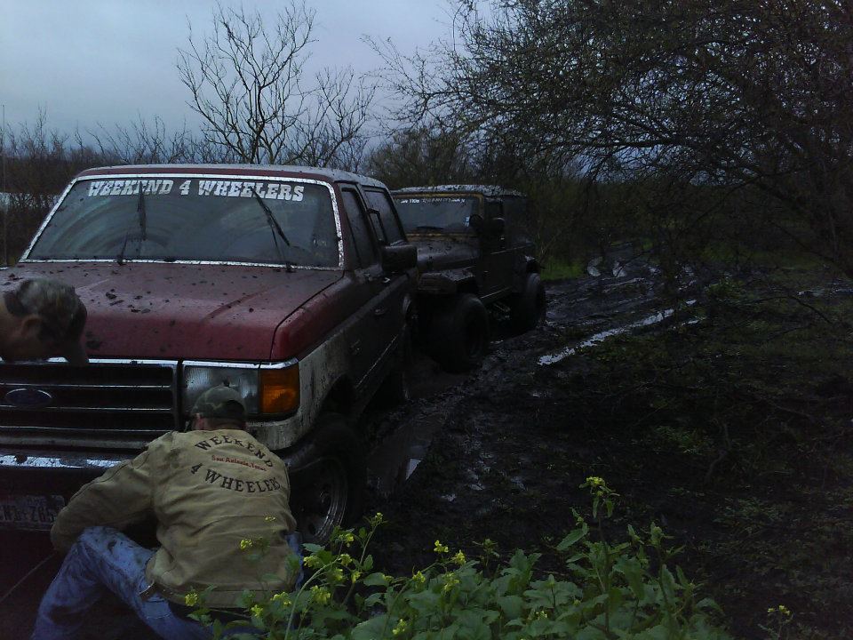 1989 Ford Bronco front end in mud, windshield banner reads WEEKEND 4 WHEELERS
