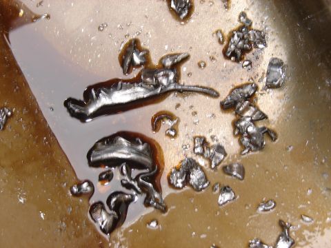 1973 Ford Ranchero - Close-up view of metal shavings suspended in dark oil, indicating potential engine wear.
