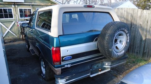 1996 Ford Bronco - Rear view of a 1996 Ford Bronco, its signature two-tone paint and spare tire carrier.