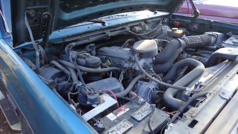 1996 Ford Bronco - The engine compartment of a vehicle is shown with various components and wiring.
