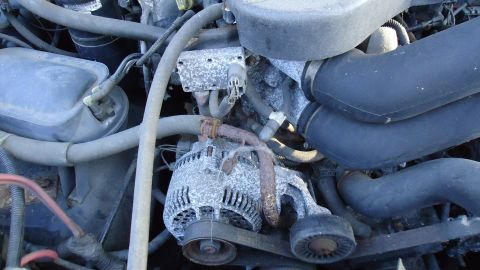 1996 Ford Bronco - Close-up view of an engine bay, focusing on the alternator and associated hoses.