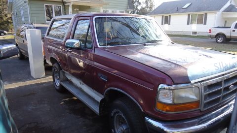 1996 Ford Bronco - Maroon 1996 Ford Bronco with a silver hood cover, parked outdoors.